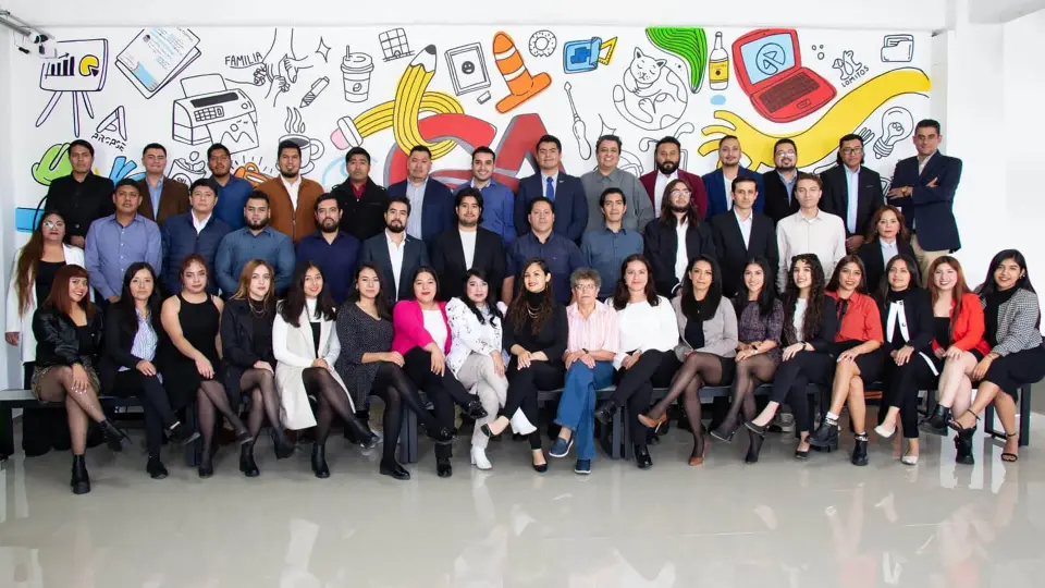 Equipo de Grupo Alveo frente a un mural ilustrado